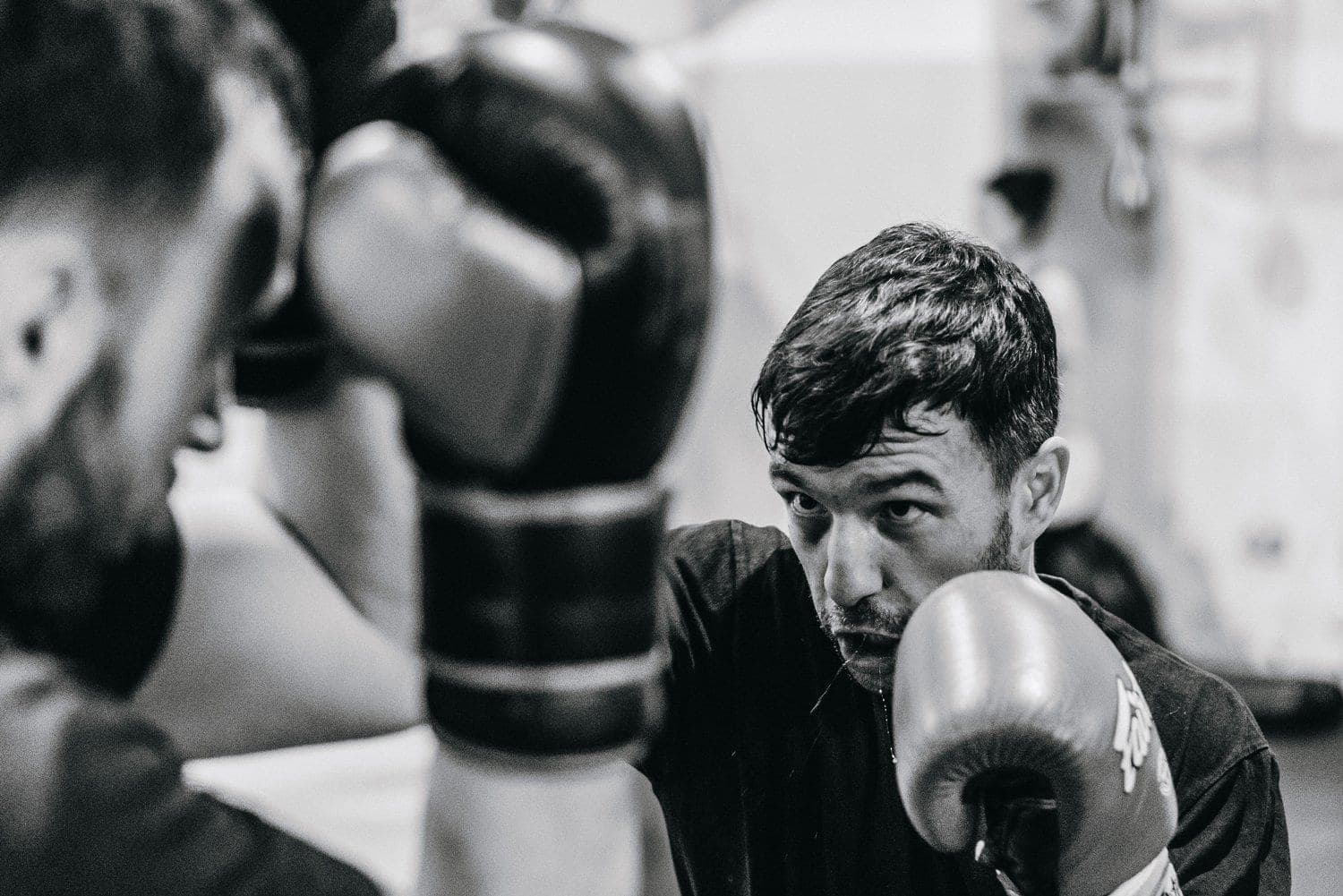A boxer watching his partner over a raised glove