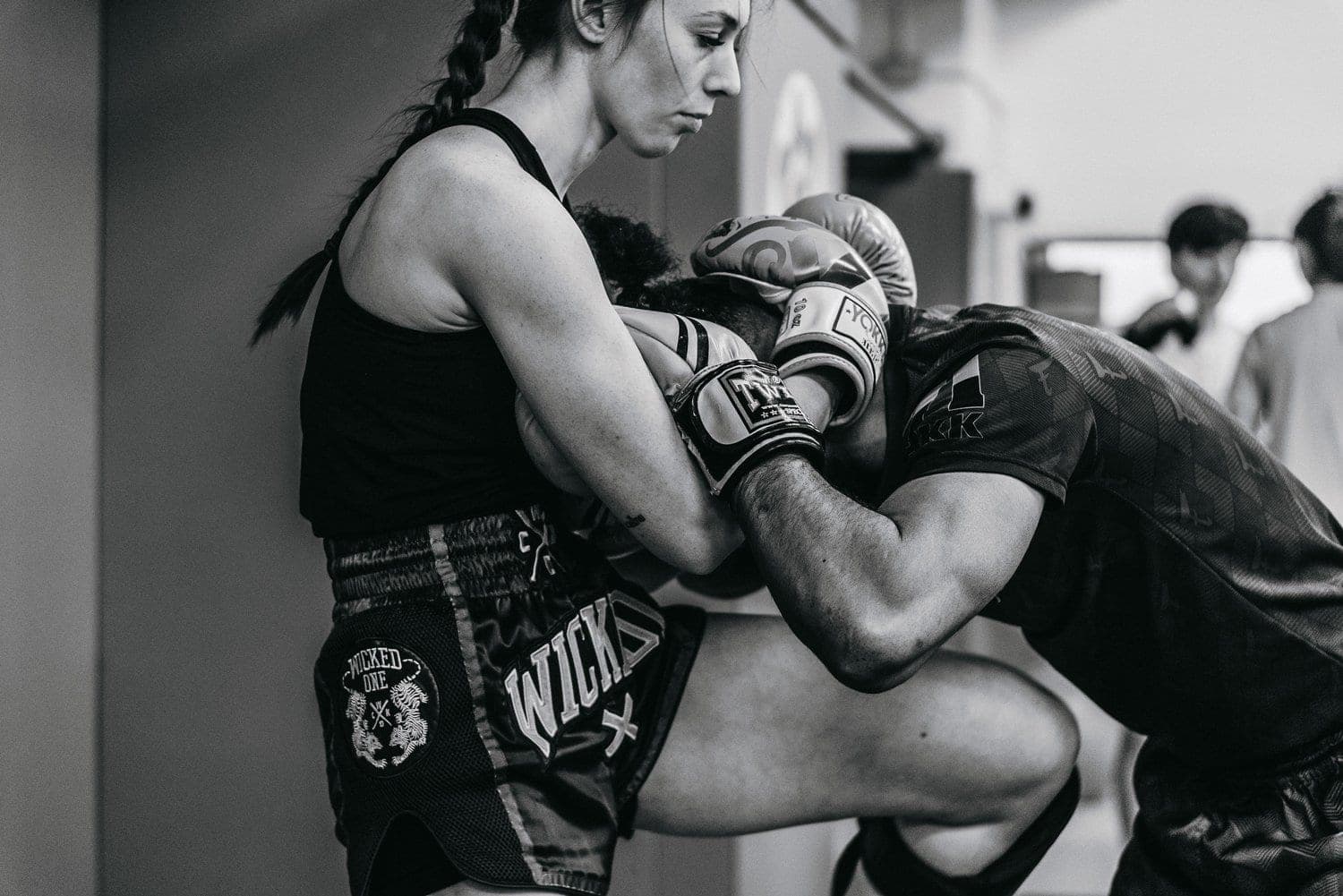 Two fighters working the clinch against the wall